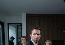 Me quedé helado en la puerta cuando mi madrastra levantó el balde y le vació agua sucia a mi madre—luego empujó a mi padre con tanta fuerza que cayó al suelo. “Hazlo otra vez,” se burló. “Parásitos.” Mi madre tosió, temblando: “Por favor… no.” Algo en mí se rompió. No grité. Solo saqué el móvil, presioné un botón y vi cómo su sonrisa se desvanecía. “¿A quién llamas?” soltó, riéndose. La miré fijo: “A todos.”