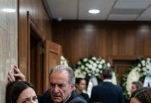 En el funeral de Javier, yo protegía mi vientre de ocho semanas cuando mis suegros me acorralaron entre coronas. —“La casa y el coche, para Lucía. Firma”, siseó mi suegra. —“Son míos”, dije… y Ramón me estampó contra la pared, el golpe me dejó sin aire. Sentí otra bofetada, uñas clavándose en mi muñeca. —“Ahora sí estás sola”, escupieron. Saqué el móvil con la boca llena de sangre: —“Hazlo”. Diez minutos después, gritaron: “¡Nos han arruinado!”… y yo apenas estaba empezando.