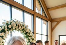 Me quedé helada en la boda de mi nieta, con el champán burbujeando en mi mano, cuando vi mi etiqueta con el nombre: “La vieja fea que está pagando por todo.” Mi sonrisa no se quebró… hasta que oí a mi nieta sisear detrás de las flores: “Solo compórtate bien, abuela… necesitamos tu dinero.” La banda seguía tocando, los invitados seguían riendo, y yo seguía mirando esa etiqueta como si fuera una advertencia. Entonces vi el sobre en el bolsillo del coordinador, con mi firma ya en él.