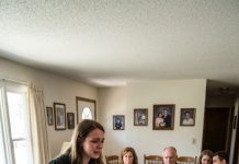 My parents didn’t show up to my graduation—not even a text. I cried alone in my gown, thinking that was the worst they could do. Then my aunt called the next morning and whispered, “They’re going house to house… borrowing money in your name.” I drove straight to their living room, dropped the paperwork on the table, and said, “Tell them the truth—or I will.”