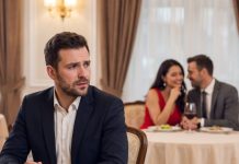 I was sitting in the restaurant holding my anniversary gift when my wife texted, “I’m stuck at work, babe. I’m sorry.” But two tables away, I watched her smile, hold hands, and kiss her millionaire boss. My whole marriage collapsed in seconds. I was ready to expose them until a stranger grabbed my arm and whispered, “Don’t do it… you need to see what happens next.” What she revealed changed everything I believed.